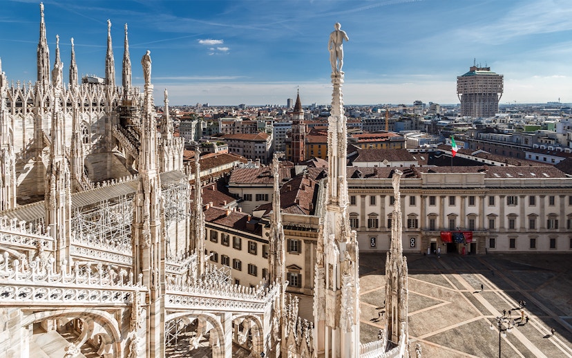 Duomo Milan rooftop view with spires and cityscape in the background.