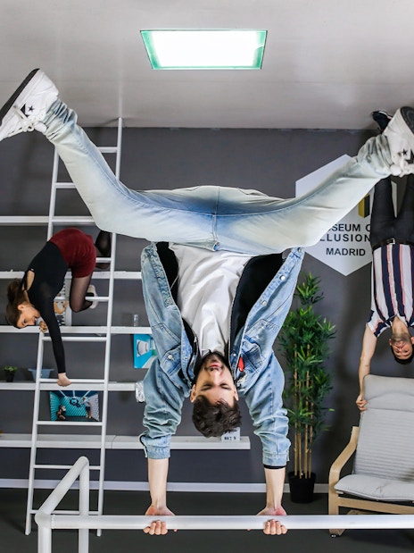 Visitors experiencing an upside-down room at the Museum of Illusions in Madrid.