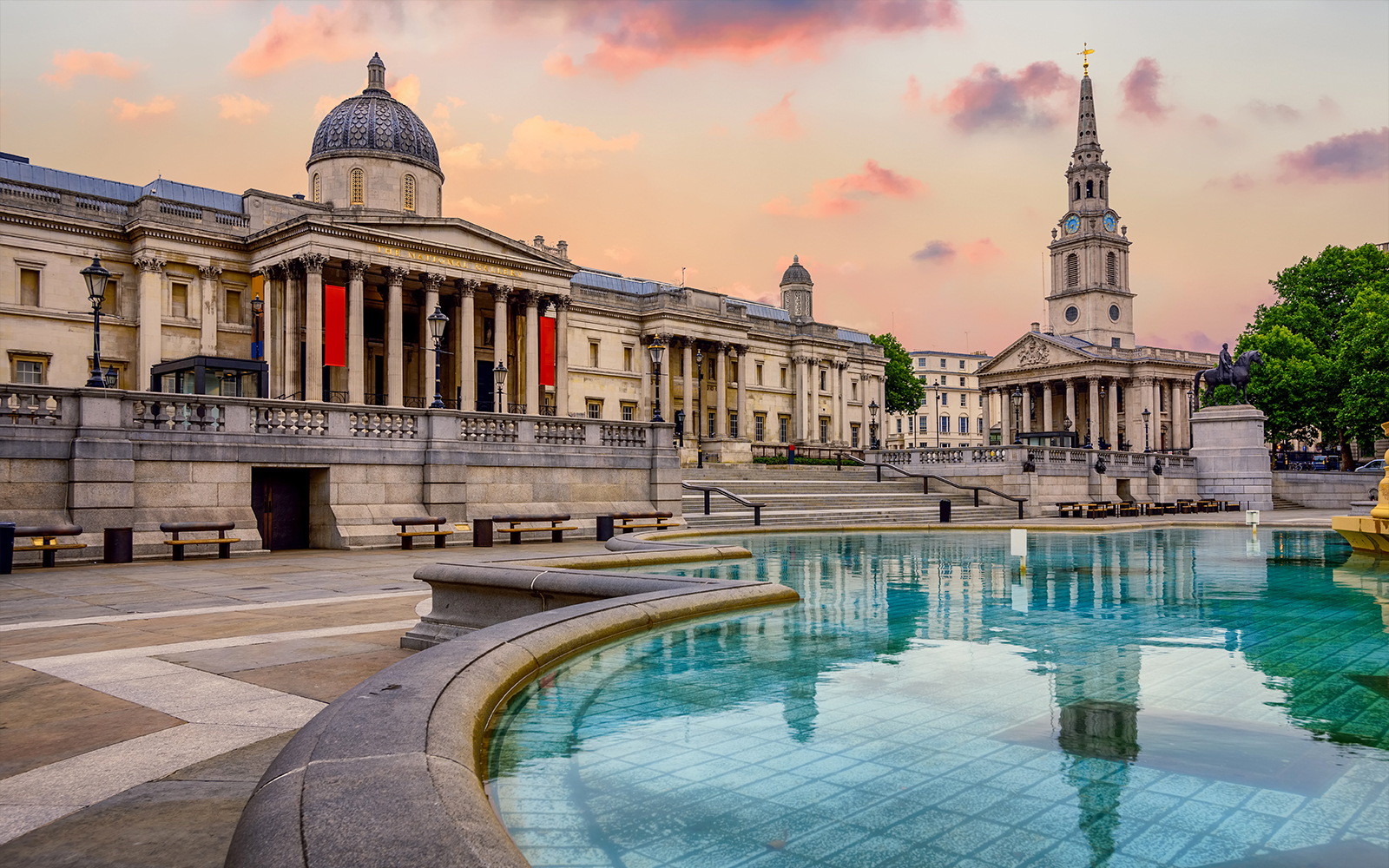 National Gallery facade at Trafalgar Square, London, England, with visitors in the foreground.
