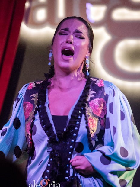 Flamenco performer singing passionately at Alegría Flamenco & Gastronomia.
