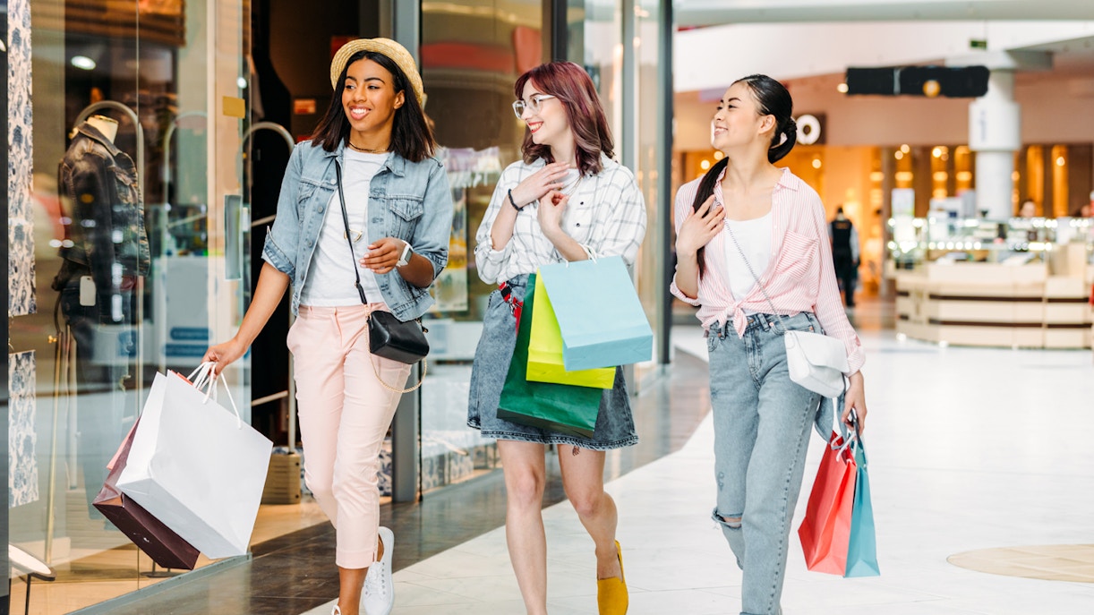 Women shopping with bags in a modern mall.