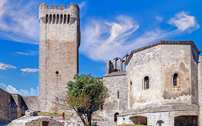 Montmajour Abbey stone tower and chapel under blue sky in Provence, France.