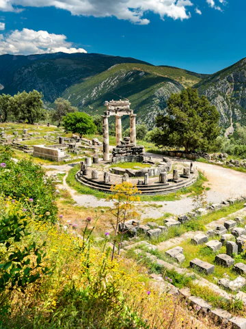 Temple of Athena Pronaia ruins with mountains in Delphi, Greece.