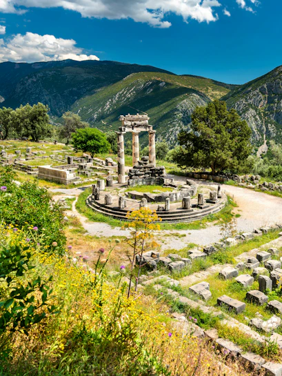 Temple of Athena Pronaia ruins with mountains in Delphi, Greece.