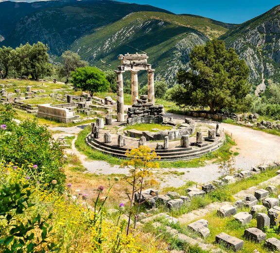 Temple of Athena Pronaia ruins with mountains in Delphi, Greece.