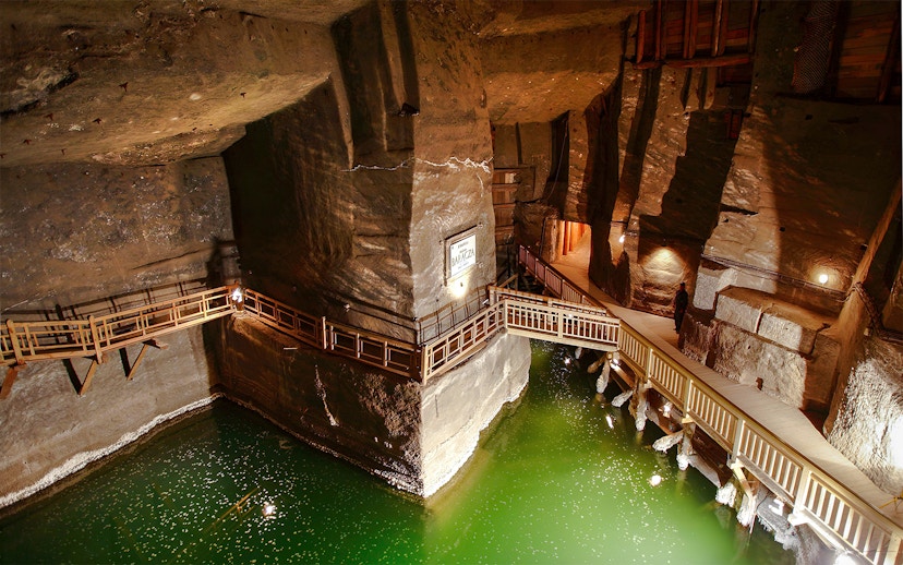 Wieliczka Salt Mine underground salt lake with wooden walkways and illuminated rock walls.