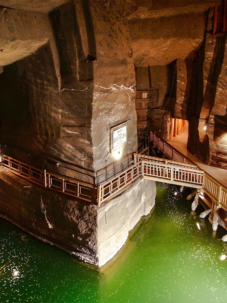 Wieliczka Salt Mine underground salt lake with wooden walkways and illuminated rock walls.
