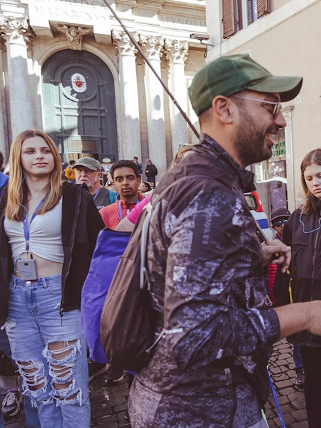 Tour group listening to a guide near Trevi Fountain, Rome.