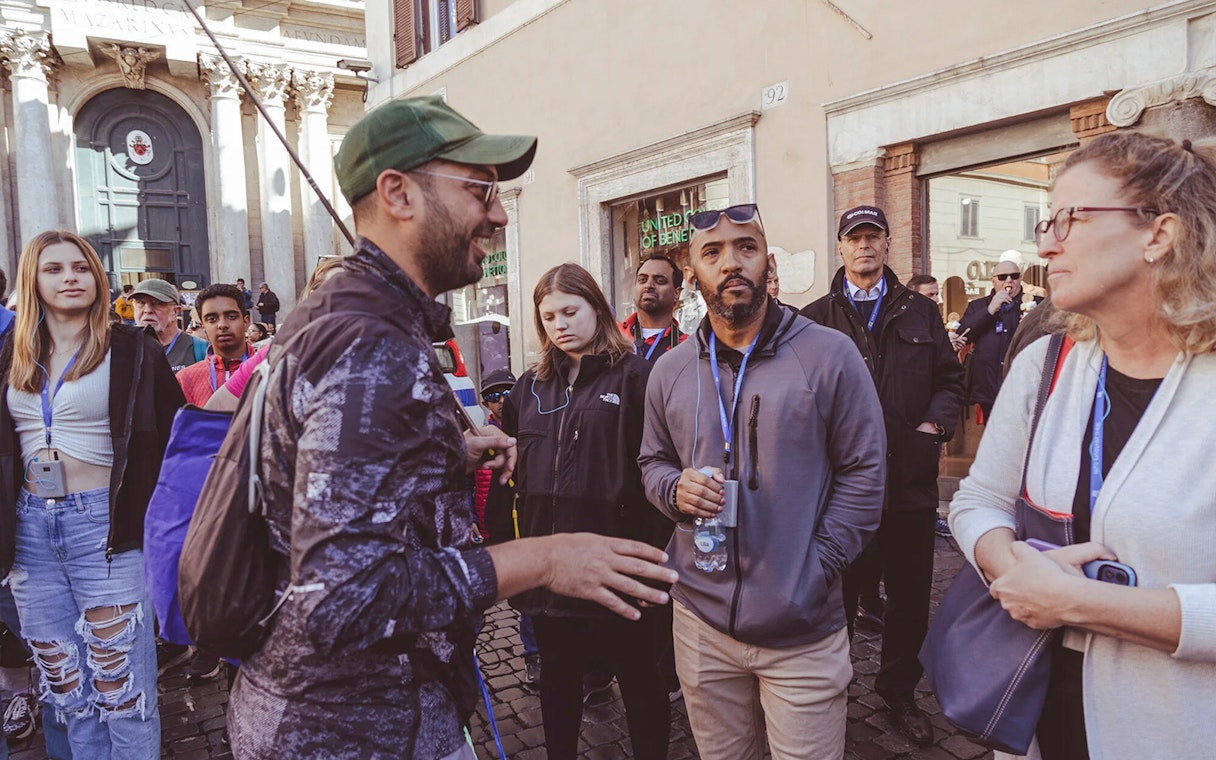 Tour group listening to a guide near Trevi Fountain, Rome.