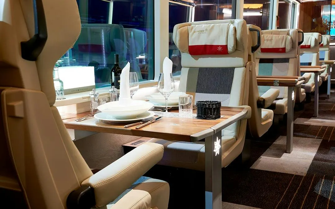 Luxurious dining setup inside Glacier Express train from Zurich to Andermatt.