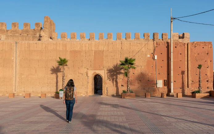 Person walking towards the ancient city wall of Taroudannt, Morocco.