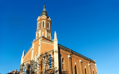 St. Paul's Church in Ruse with its brick facade and tall steeple against a clear blue sky.