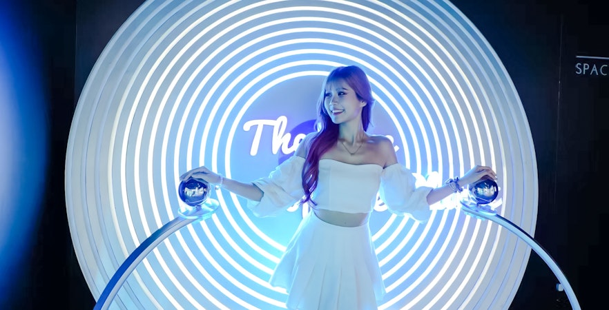 Person interacting with a light installation at Space & Time Cube in Bangkok.