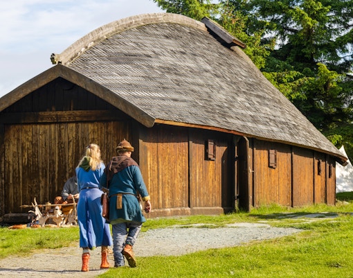 Visitors exploring Viking longhouse in Avaldsnes, Haugesund.