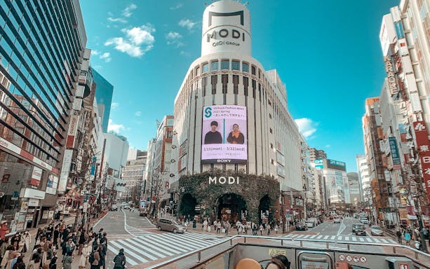 Tokyo street view from Sky Hop Bus with MODI building and Shibuya Fashion Week sign.