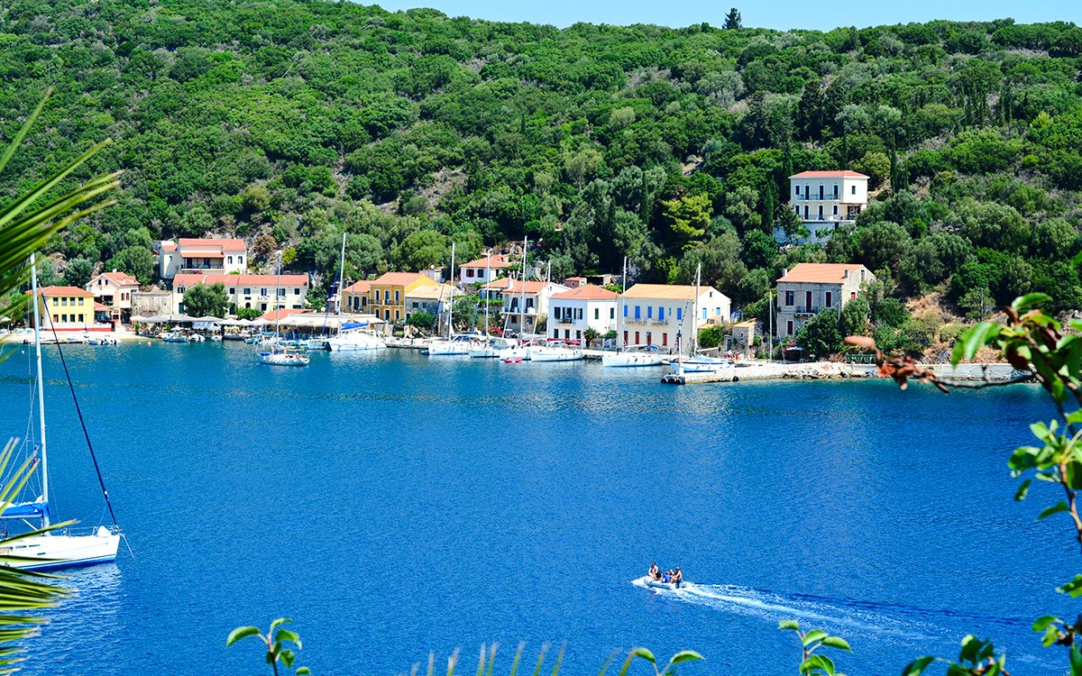 Sailboats docked along the waterfront of Kioni village, Greece.
