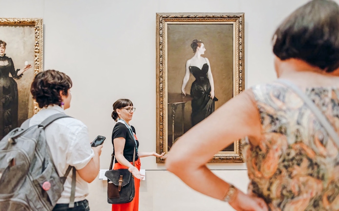 Visitors and tour guide at the Metropolitan Museum of Art viewing Portrait of Madame X by John Singer Sargent.