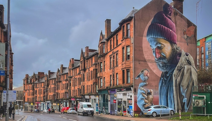 Street mural of a man with a bird on his finger, Glasgow mural trail.