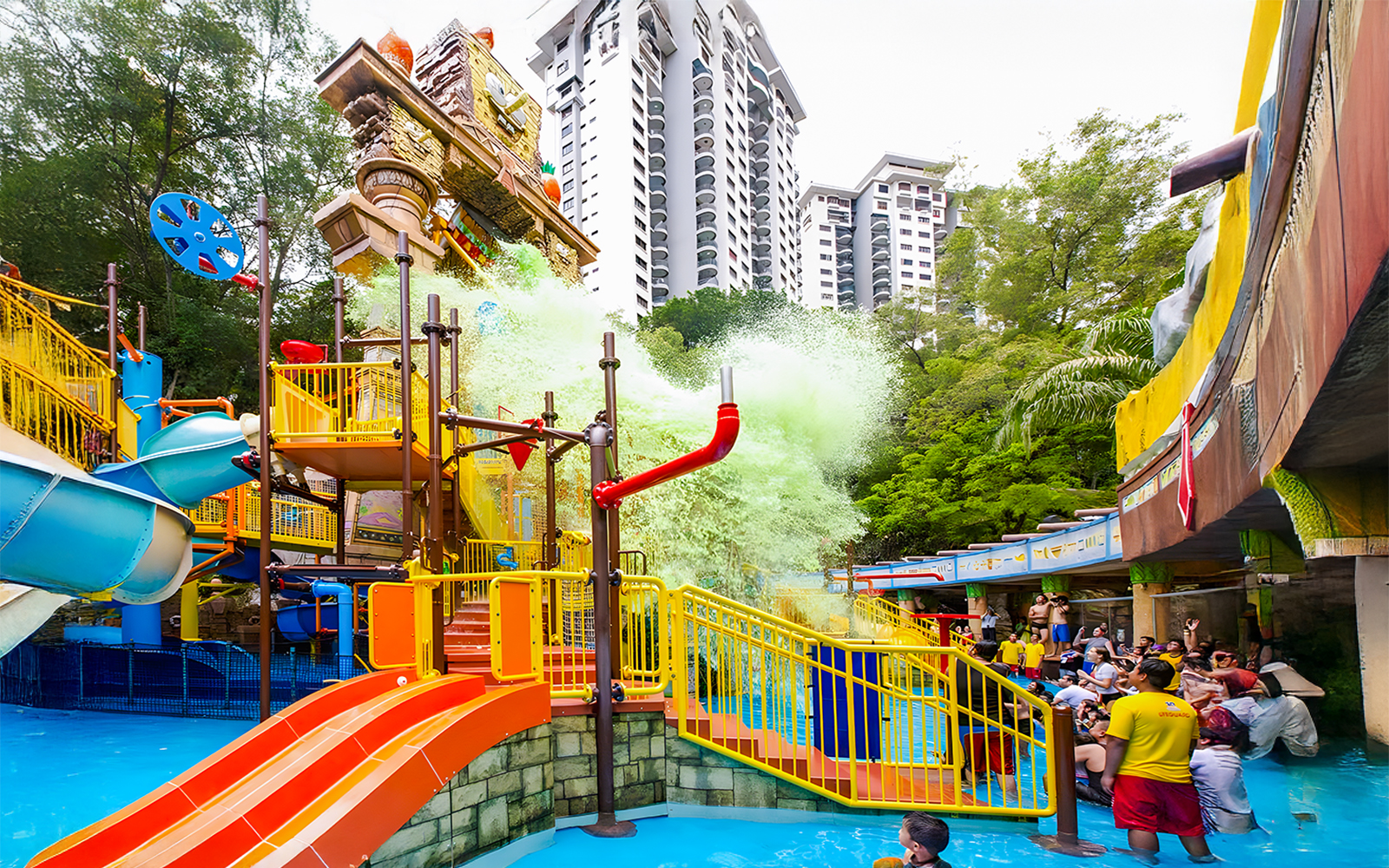 Sunway Lagoon water park splash area with slides and people enjoying the attractions.