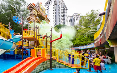 Sunway Lagoon water park splash area with slides and people enjoying the attractions.