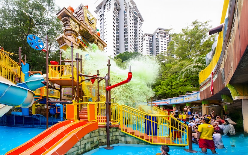 Sunway Lagoon water park splash area with slides and people enjoying the attractions.