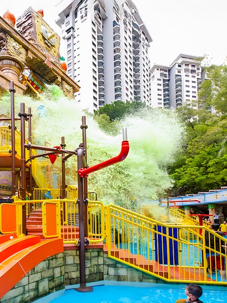 Sunway Lagoon water park splash area with slides and people enjoying the attractions.