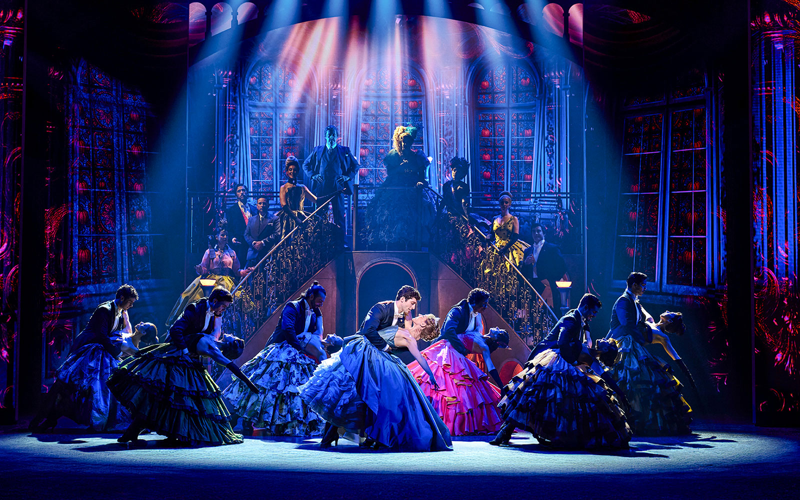 Cinderella stage performance in Madrid with dancers in colorful costumes and grand staircase backdrop.