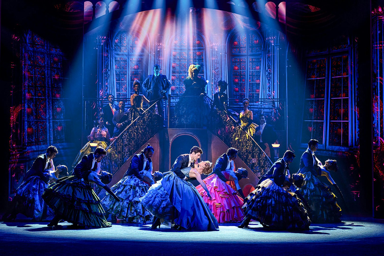 Cinderella stage performance in Madrid with dancers in colorful costumes and grand staircase backdrop.