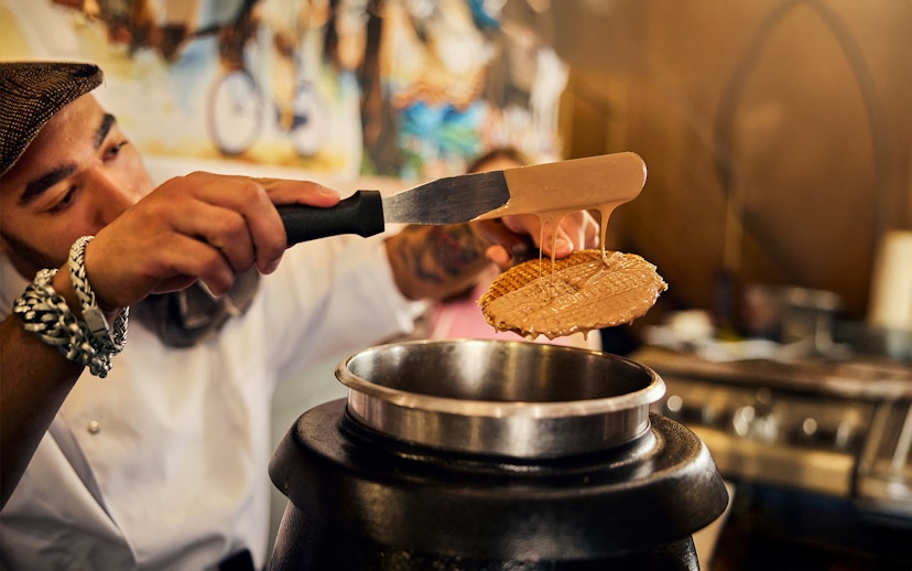 Waffle being coated with caramel at Dutch Waffle Making Workshop.