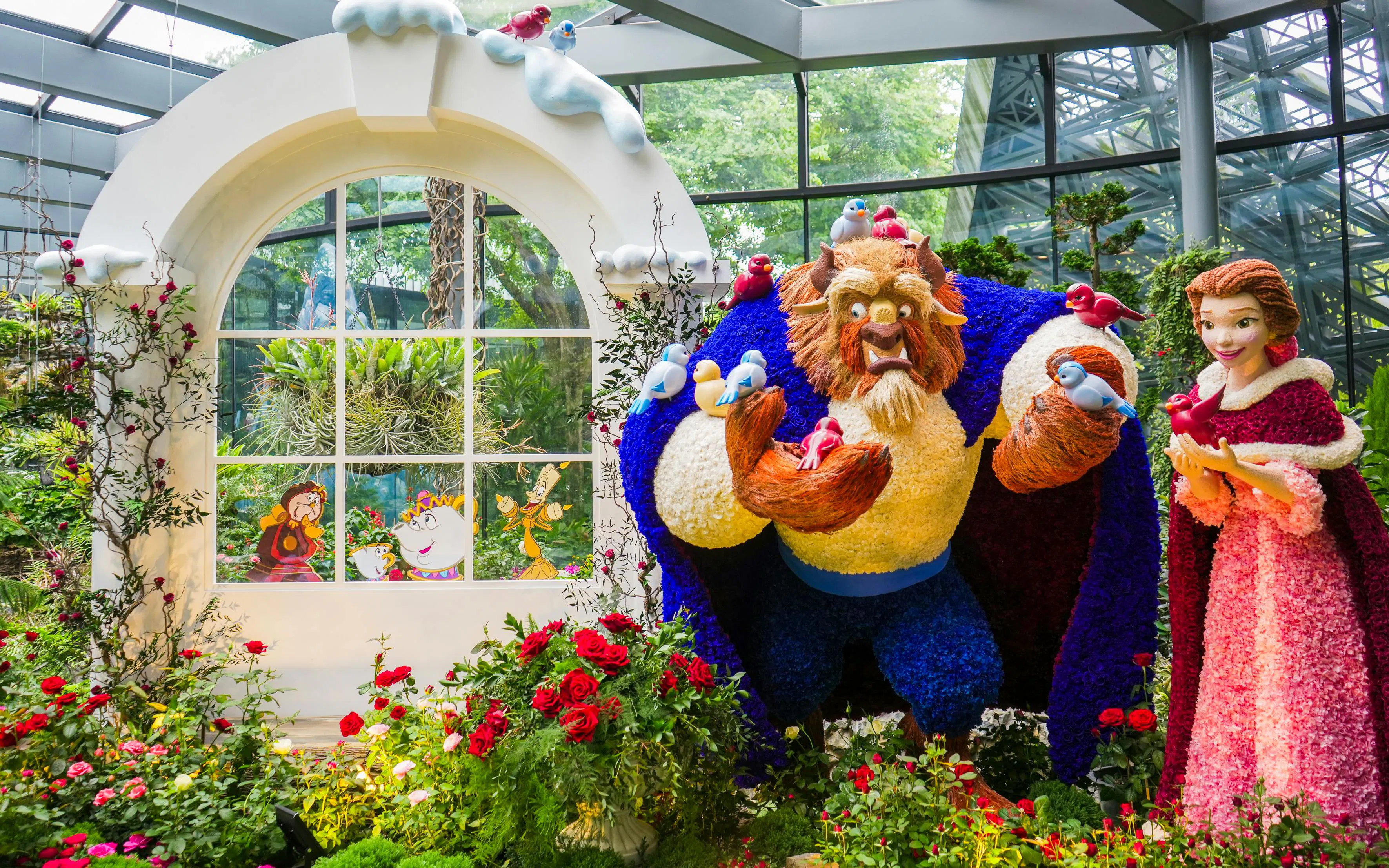 Disney Garden of Wonder with floral sculptures of characters in a vibrant greenhouse setting.
