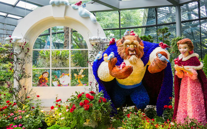 Disney Garden of Wonder with floral sculptures of characters in a vibrant greenhouse setting.
