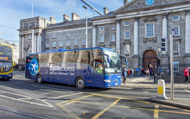 Dublin Express bus in front of historic building, offering one-way tickets from Belfast to Dublin Airport.