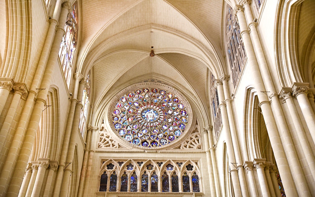 Stained glass rose window inside the Cathedral of Toledo during guided tour.