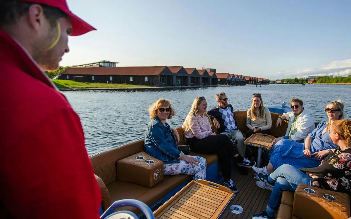 Guests on a guided boat tour in Copenhagen, enjoying views of waterfront buildings.