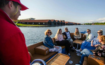 Guests on a guided boat tour in Copenhagen, enjoying views of waterfront buildings.