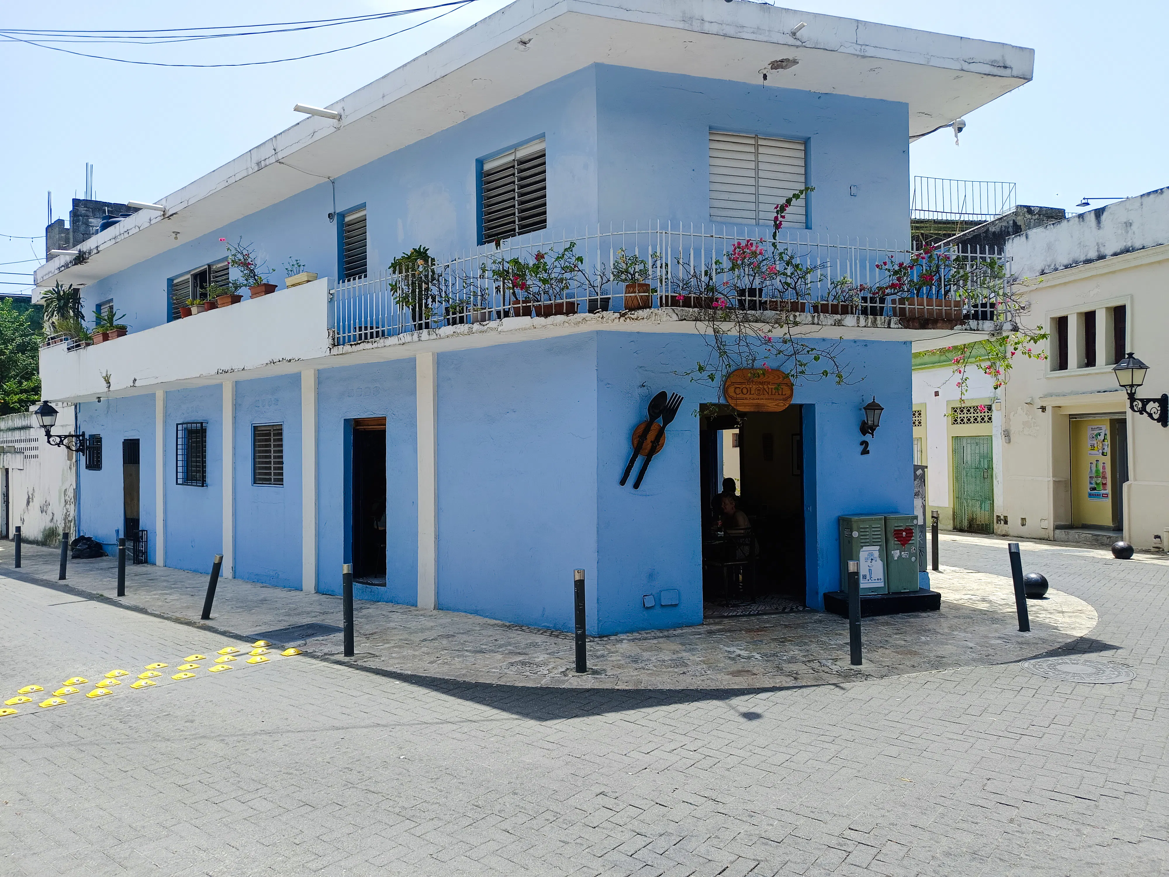 Blue building with balcony plants in Santo Domingo's Chinatown on a food walking tour.