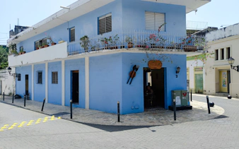 Blue building with balcony plants in Santo Domingo's Chinatown on a food walking tour.