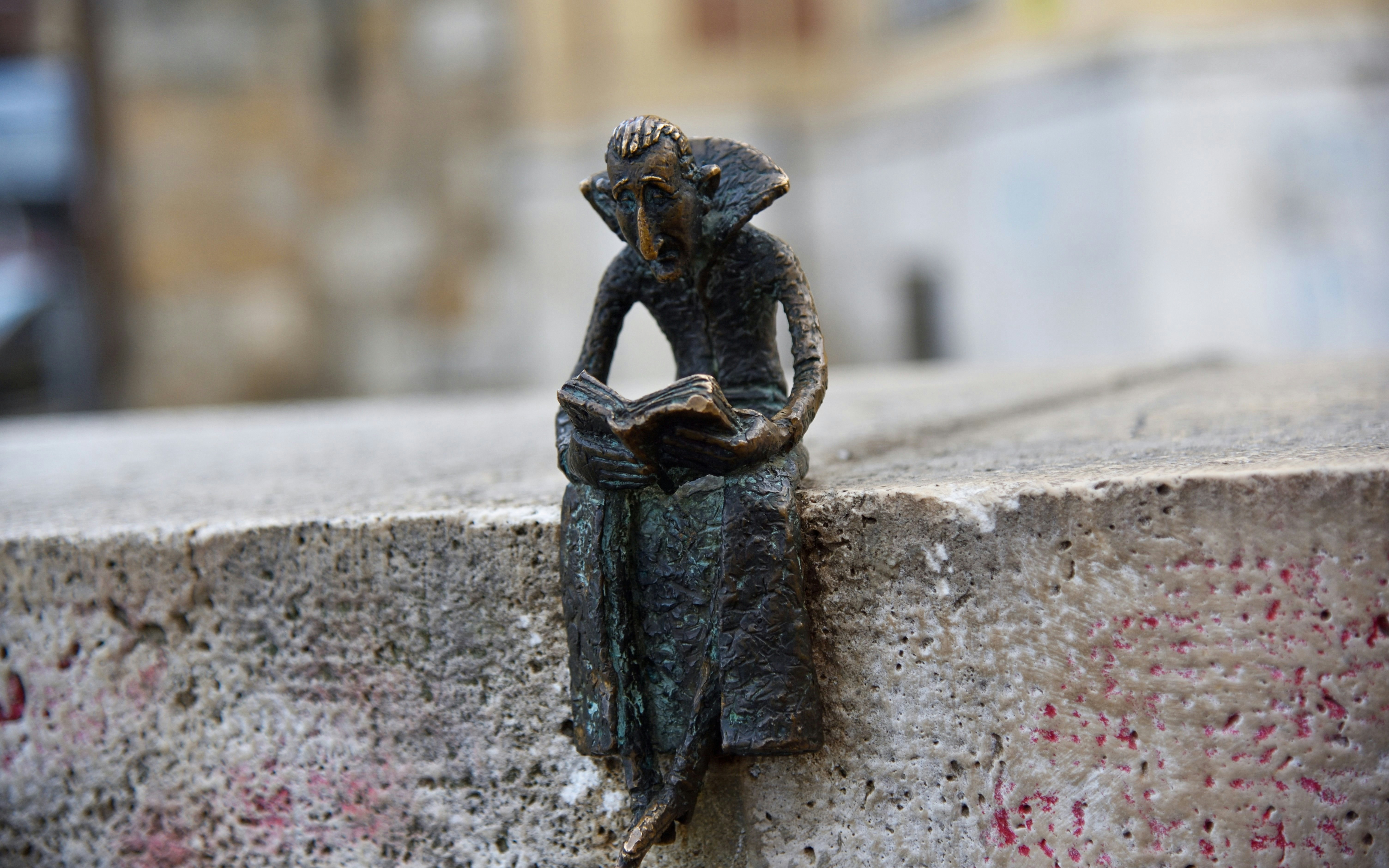 Small Dracula sculpture reading near Vajdahunyad Castle, Budapest.