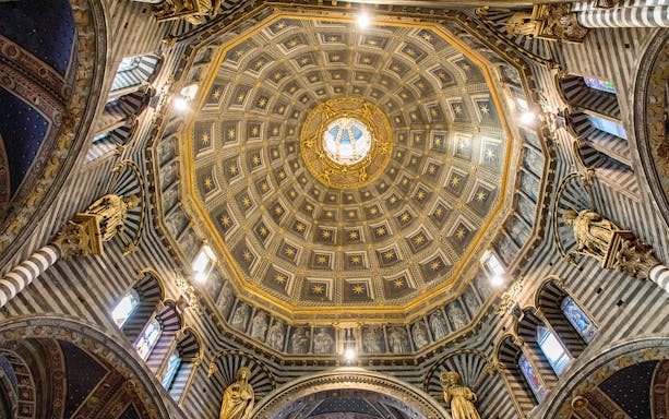 Siena Cathedral dome interior with ornate gold and blue star patterns.