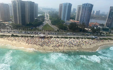 Aerial view of crowded Rio de Janeiro beach with high-rise buildings during VIP helicopter tour.