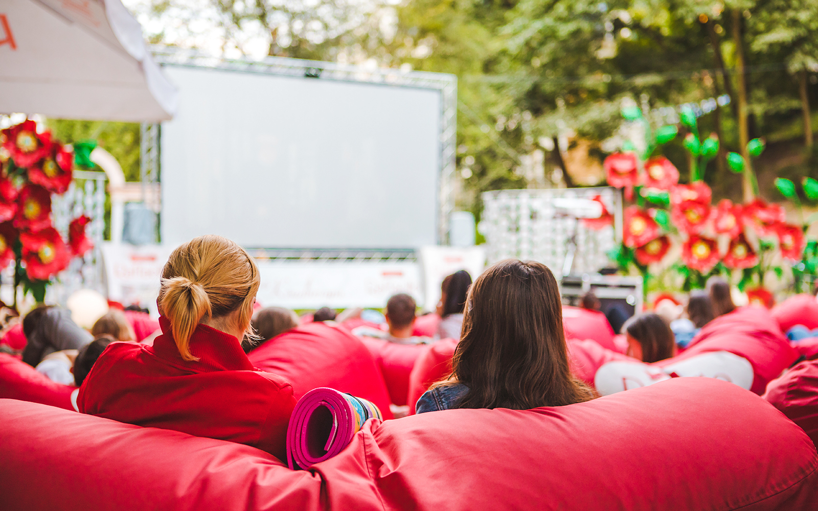 Open-air cinema at barcelona, with audience on red bean bags.