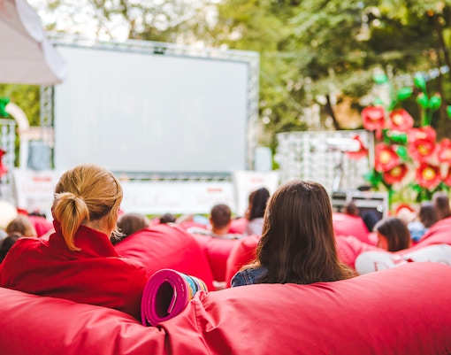 Open-air cinema at barcelona, with audience on red bean bags.