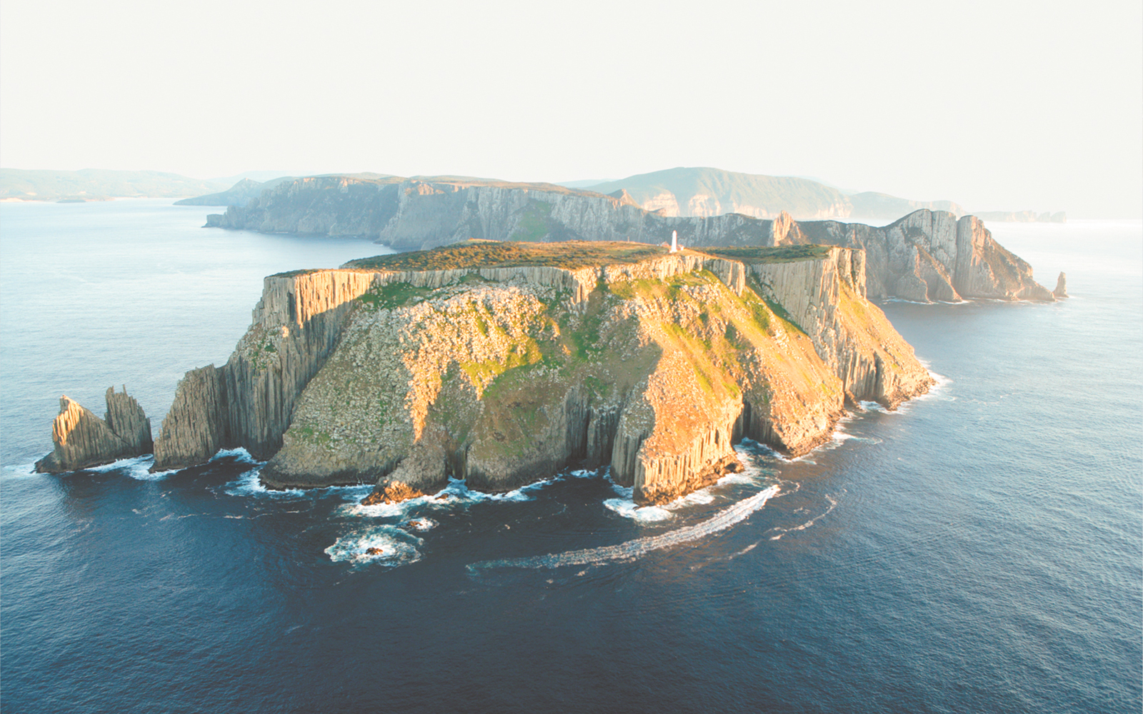 Tasman Island cliffs and lighthouse viewed from the ocean during a full-day tour from Hobart.