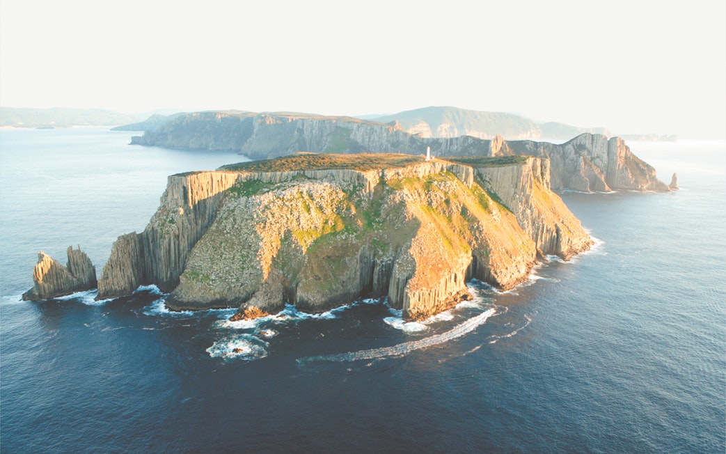 Tasman Island cliffs and lighthouse viewed from the ocean during a full-day tour from Hobart.