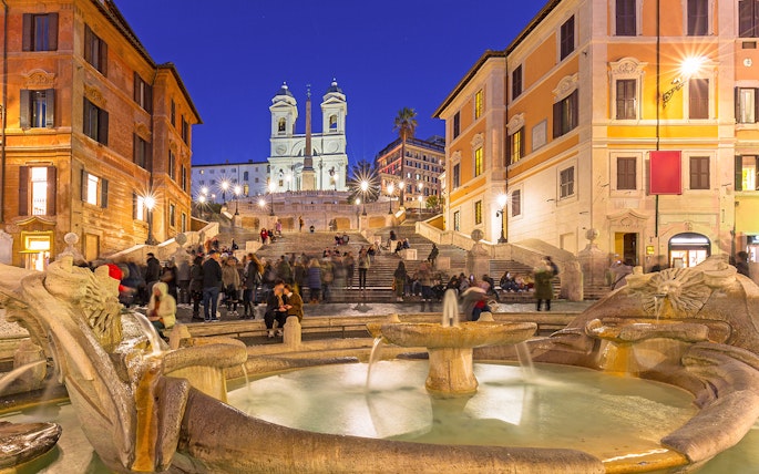 Fountain at Piazza di Spagna with Spanish Steps in Rome at dusk, Italy.