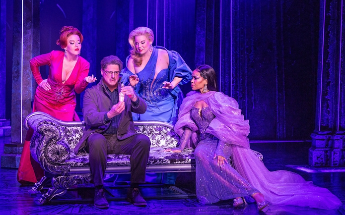 Four actors in colorful costumes on stage in a scene from "Death Becomes Her" musical.