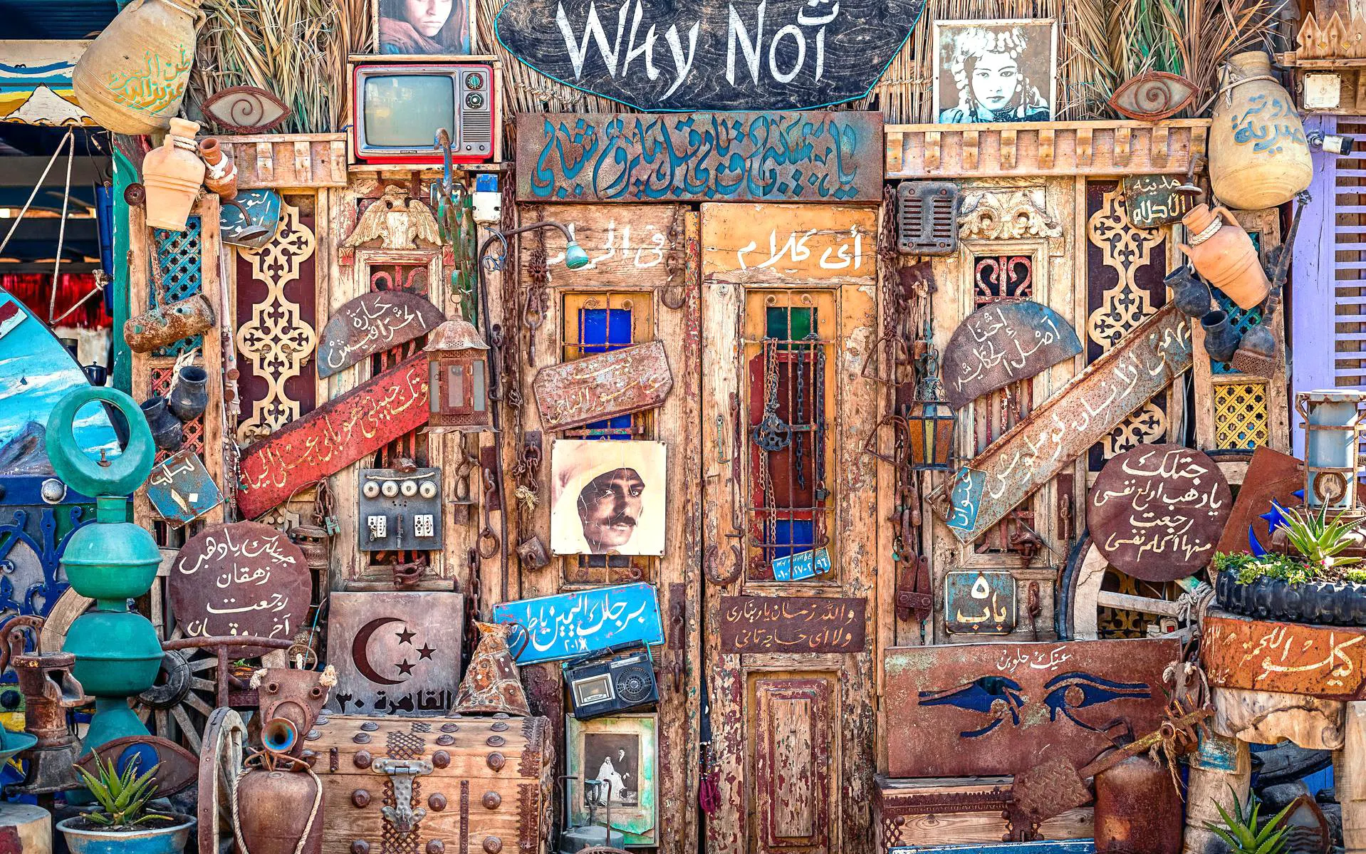 Colorful Sharm El-Sheikh cafe entrance with eclectic decor and Arabic signs.