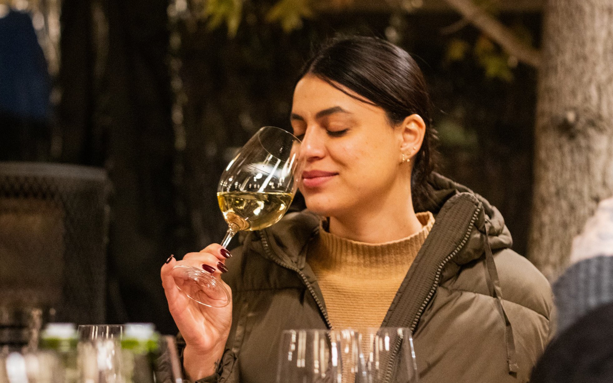 Woman enjoying wine at Concha y Toro vineyard tasting event.
