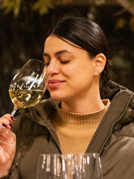 Woman enjoying wine at Concha y Toro vineyard tasting event.