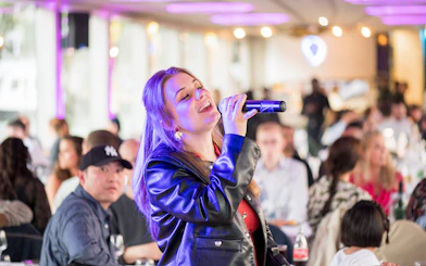 Singer performing on Le Diamant Bleu cruise with audience in background.